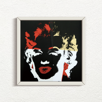 a sunday b morning print after andy warhol titled 'golden marilyn 39' in white frame. the artwork features a negative image of marilyn monroe's face on a black background, colourised in red, yellow, and white. this is a sunday b morning print for sale