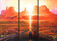 A three-panel canvas wall art print depicting a desert landscape at sunset with red rock buttes, a glowing sun, and a road leading toward the horizon. The artwork fills the entire frame.