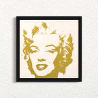 an image of an artwork by andy warhol titled 'golden marilyn 41' in black frame.  the artwork features a stencilled image of marilyn monrow's face in gold on a white background. this is a sunday b morning print