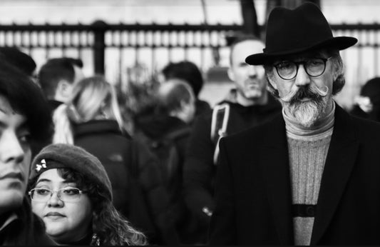 Black and White Photography from AJ Curtis taken in Traffalgar square of a man who looks like a poet with a moustache 