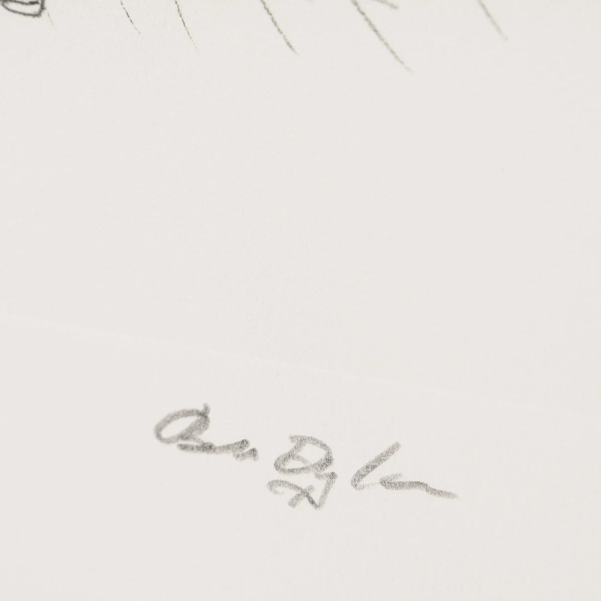A close-up of a white surface with a faint gray pencil signature and a few partial sketch lines near the top edge from the artist Bob Dylan 