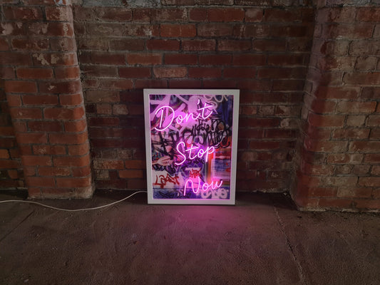Infuse your space with creativity and energy with Tony Spink's Don't Stop Now. This one-of-a-kind artwork features purple neon on a graffiti canvas backing, elegantly presented in a white wooden frame. Measuring 65 x 85 cm, this original masterpiece is a unique fusion of neon art and urban flair. Elevate your space with this distinctive neon artwork, a dynamic addition to any art collection.