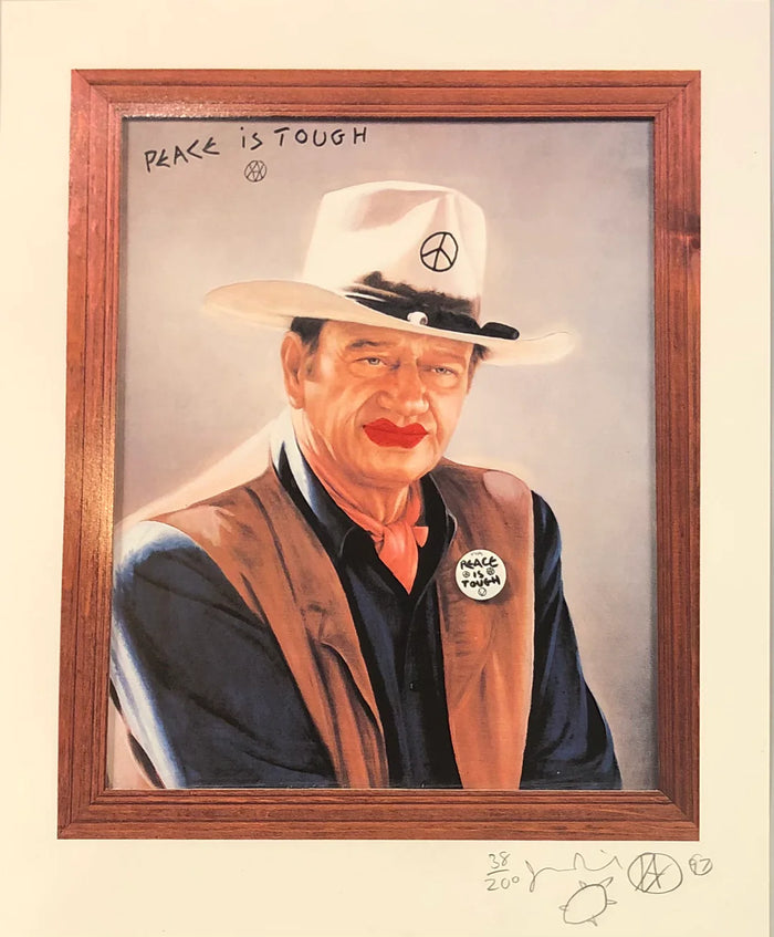 Framed artwork by jamie reid featuring a man in a cowboy hat with a peace sign on it, stating PEACE IS TOUGH