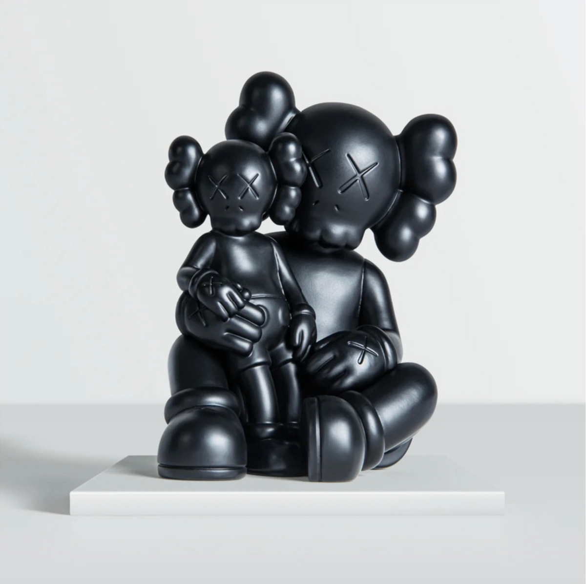 KAWS Shelter bronze figure holding a mini version of himself
