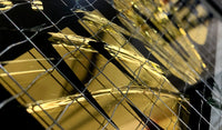 Embrace the art of controlled chaos with Mark Petty's A Glass Act (Gold). This limited edition screen print on reinforced wired glass features a reverse 2-color hand-pulled design with a striking 23.5ct gold gild. Each piece is meticulously smashed, layered up, and framed, creating a unique and unpredictable visual experience. Framed size is 27 x 32 cm. Each artwork comes with a signed plaque, displaying the title on the right side of the frame, and a signed certificate of authenticity on the back.