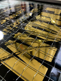 Embrace the art of controlled chaos with Mark Petty's A Glass Act (Gold). This limited edition screen print on reinforced wired glass features a reverse 2-color hand-pulled design with a striking 23.5ct gold gild. Each piece is meticulously smashed, layered up, and framed, creating a unique and unpredictable visual experience. Framed size is 27 x 32 cm. Each artwork comes with a signed plaque, displaying the title on the right side of the frame, and a signed certificate of authenticity on the back.